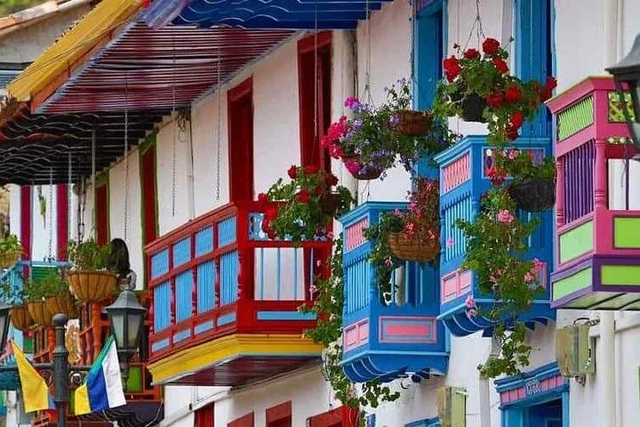Bunt bemalte Holzbalkone mit hängenden Blumenkörben an traditionellen Häusern